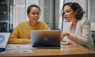 two people looking at laptop screen and discussing