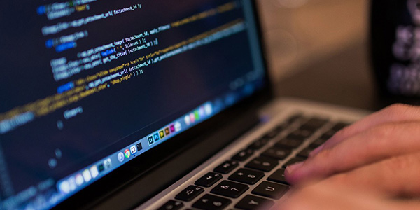 person coding on laptop