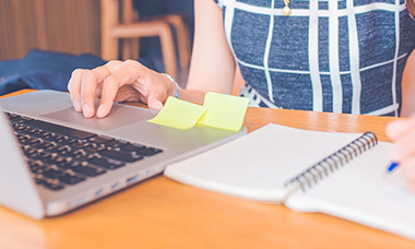 person editing with laptop and notebook