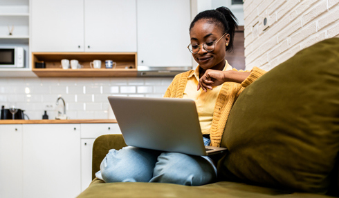 Woman sitting in a chair working on a laptop 