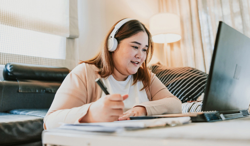 Woman with headphones working on a laptop